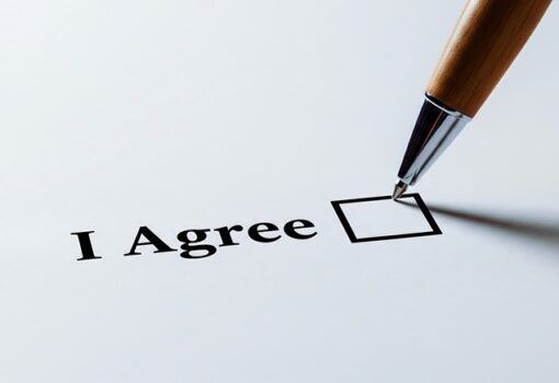 Weißes Blatt, auf dem steht: I agree, ein Stift will abhaken