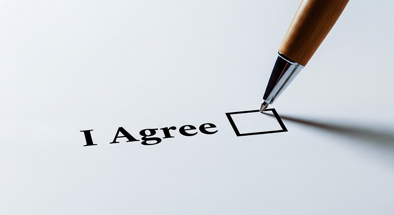 Weißes Blatt, auf dem steht: I agree, ein Stift will abhaken