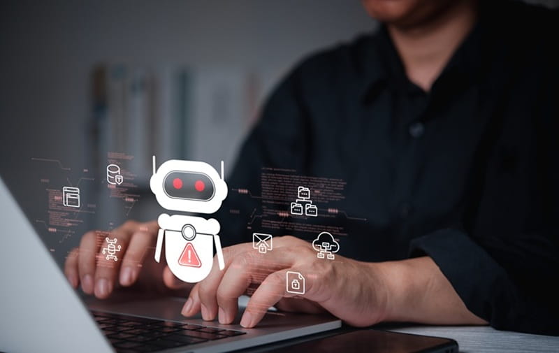 Mann an Tastatur, vorne ein Chatbot